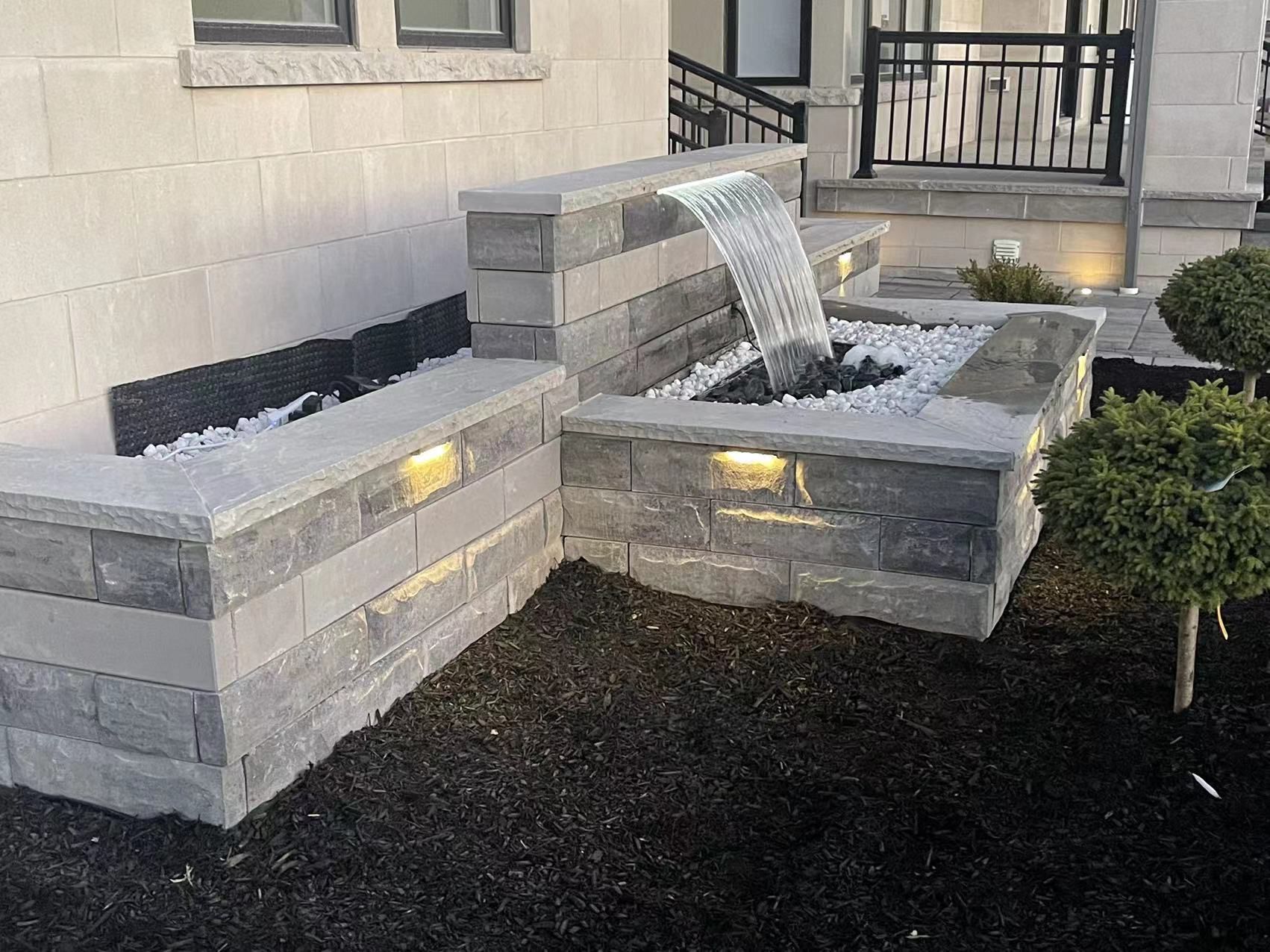 Stone waterfall and retaining wall with lighting